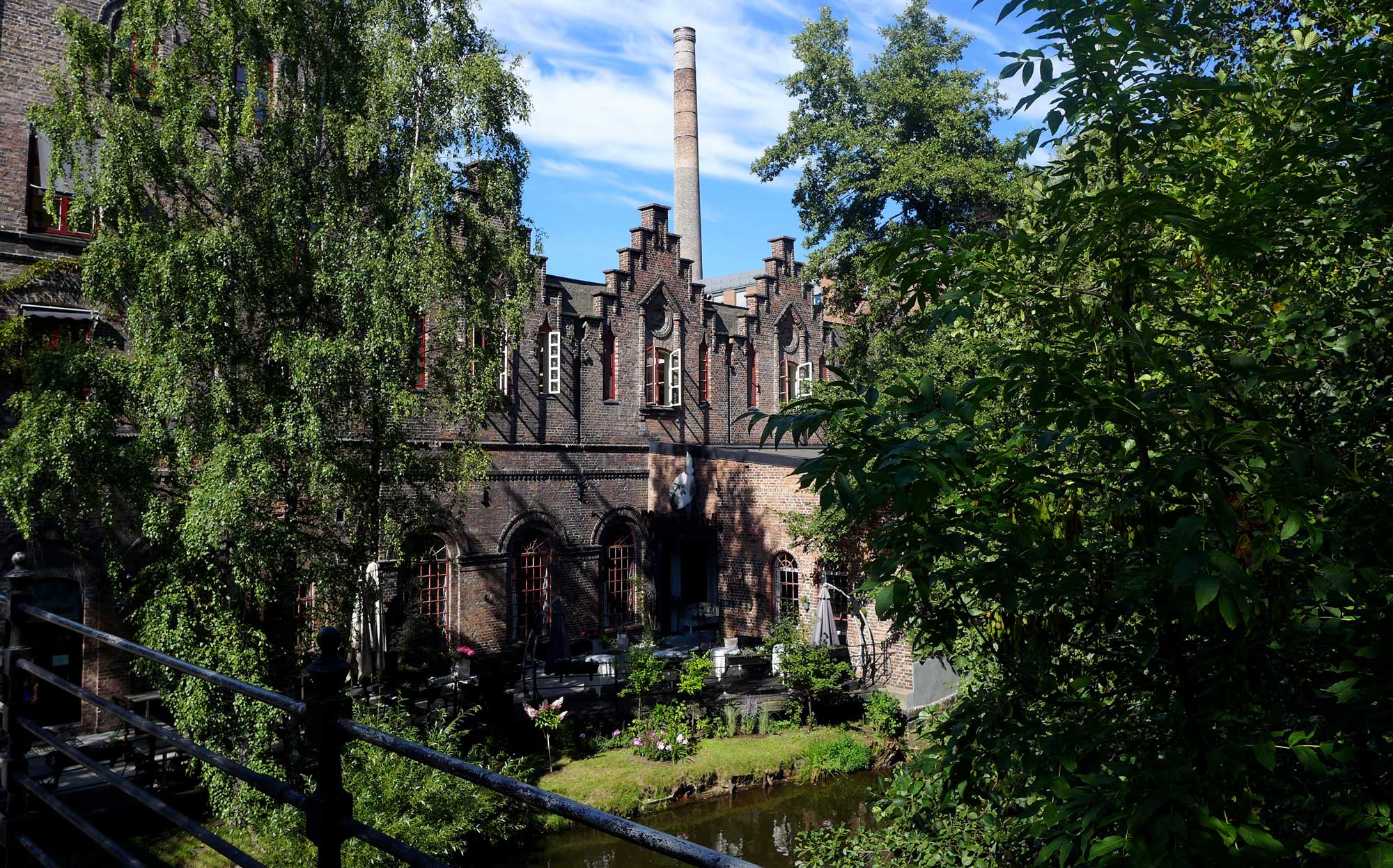 Månefisken ved Akerselva med murstein og grønt løvverk.
